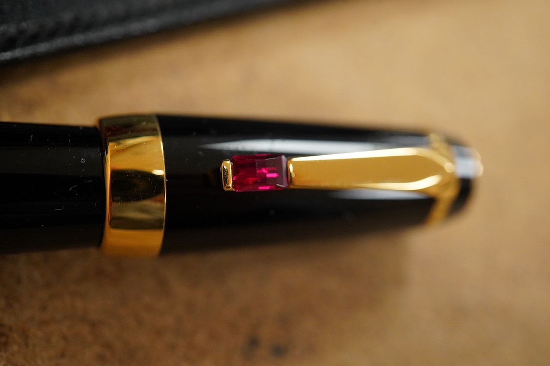 A leather cased Mont Blanc pen with retractable nib and decorative jewelled clip, 11cm long